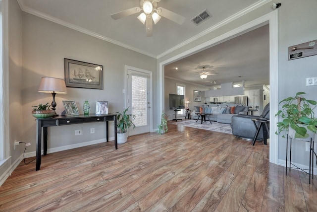 foyer entrance with crown molding, light hardwood / wood-style flooring, and ceiling fan