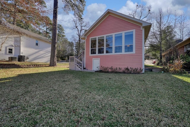 view of side of home with a lawn and central AC unit