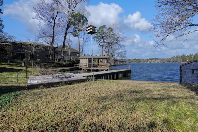 view of dock with a water view and a yard