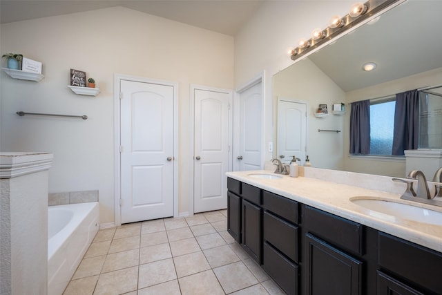 bathroom featuring tile patterned flooring, vanity, a tub to relax in, and lofted ceiling