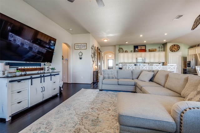 living room with ceiling fan and dark hardwood / wood-style floors