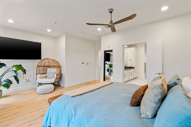 bedroom with ensuite bath, ceiling fan, and light hardwood / wood-style flooring