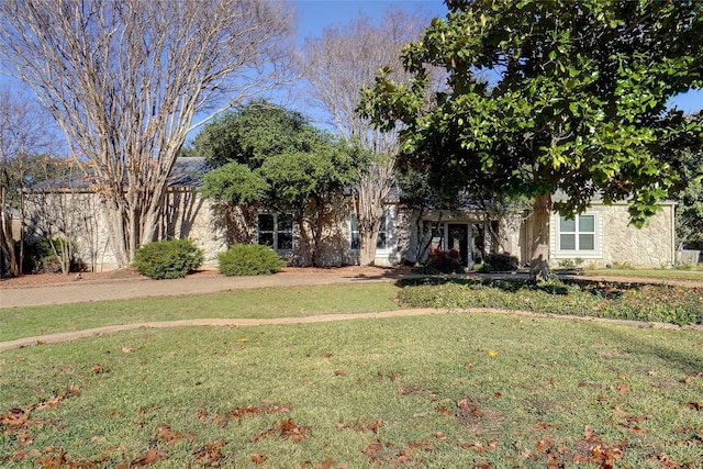 view of property hidden behind natural elements featuring a front lawn