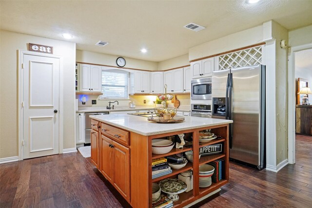 kitchen featuring a center island, white cabinets, dark hardwood / wood-style floors, and appliances with stainless steel finishes