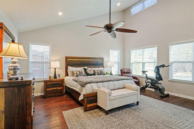 bedroom featuring ceiling fan, dark hardwood / wood-style flooring, high vaulted ceiling, and a textured ceiling