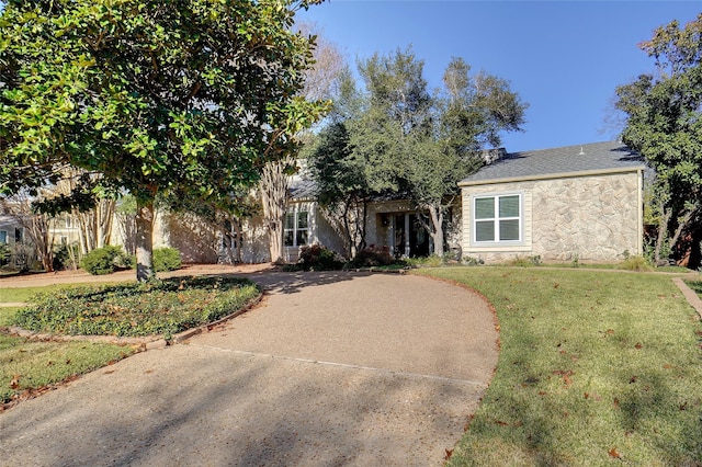 obstructed view of property with a front lawn