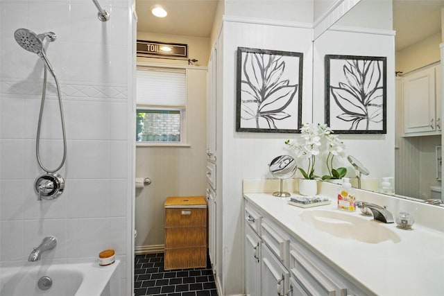 full bathroom featuring tile patterned floors, tiled shower / bath, vanity, and toilet