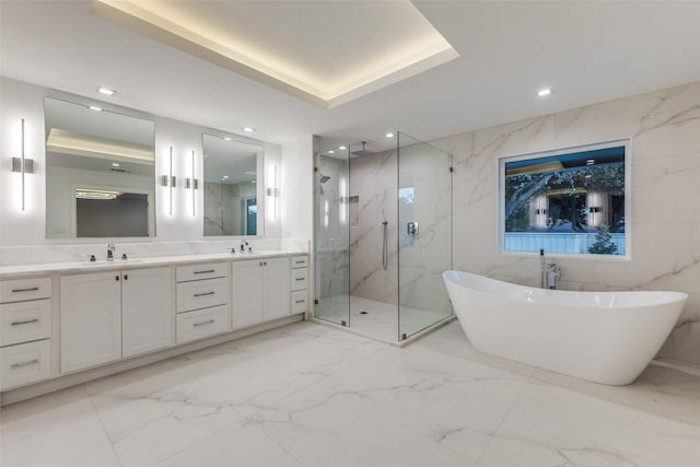 bathroom featuring vanity, tile walls, and shower with separate bathtub