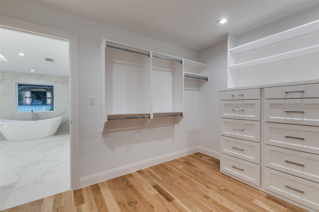 walk in closet with light wood-type flooring