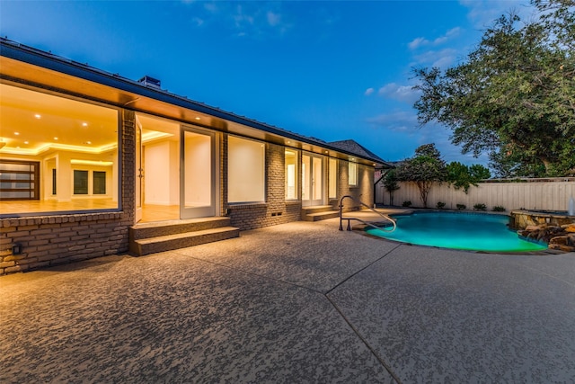 pool at dusk featuring a patio area