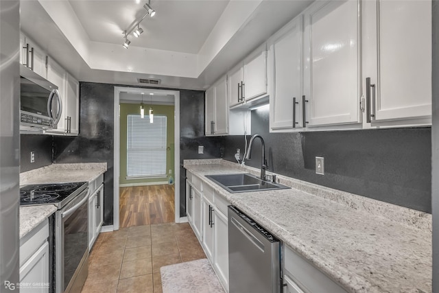 kitchen with white cabinetry, sink, decorative backsplash, and stainless steel appliances