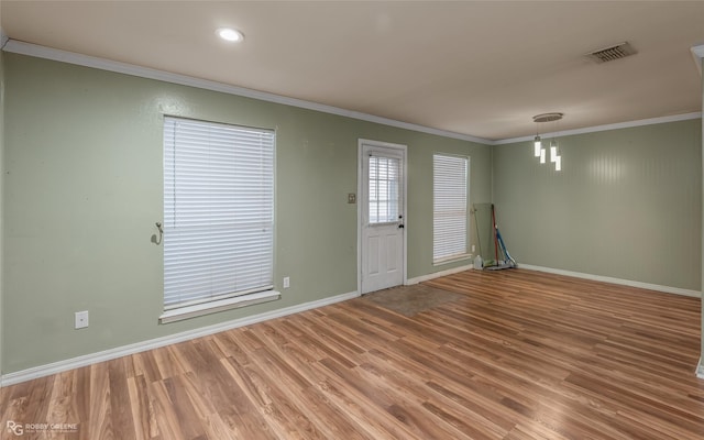 empty room with wood-type flooring and ornamental molding