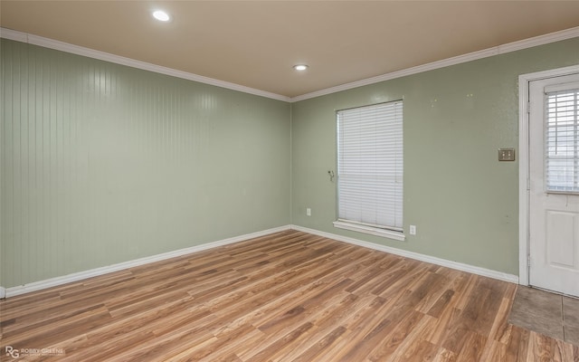 empty room featuring wood-type flooring and ornamental molding