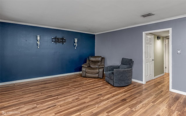 living area with hardwood / wood-style floors and ornamental molding