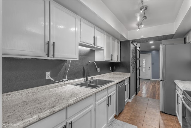 kitchen with stainless steel appliances, sink, and white cabinets