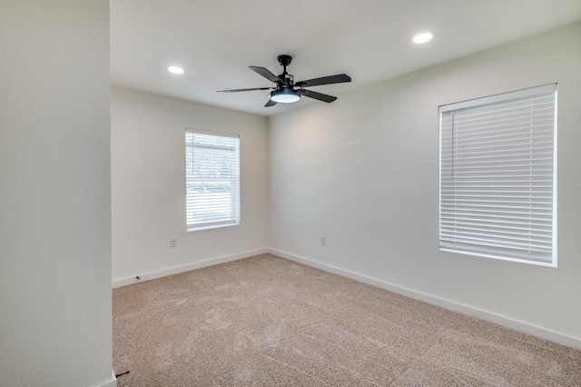 empty room with ceiling fan and light colored carpet