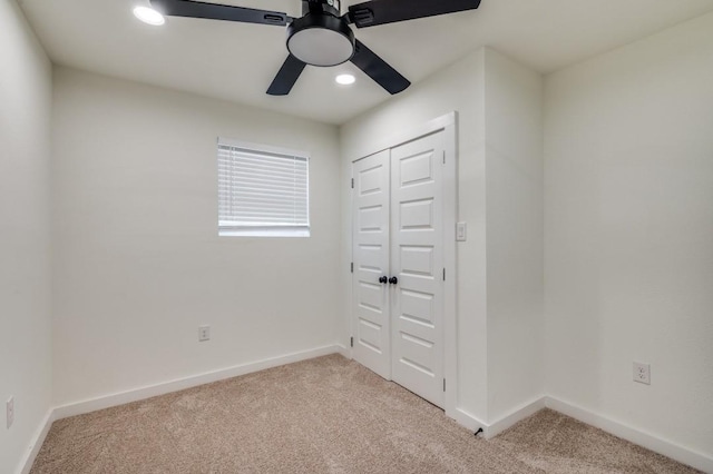 unfurnished bedroom featuring ceiling fan, a closet, and light carpet