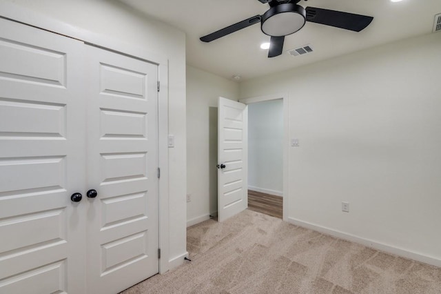 unfurnished bedroom with light colored carpet and ceiling fan