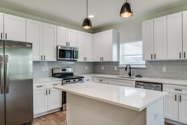 kitchen featuring pendant lighting, white cabinets, and appliances with stainless steel finishes