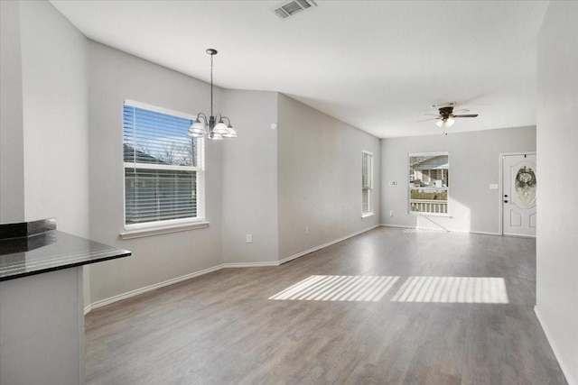 interior space with wood-type flooring and ceiling fan with notable chandelier