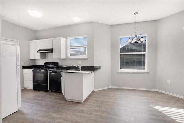 kitchen with an inviting chandelier, black appliances, hanging light fixtures, light hardwood / wood-style floors, and white cabinetry