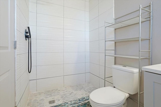 bathroom featuring vanity, toilet, and tiled shower