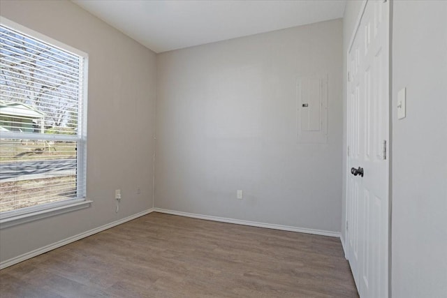 unfurnished room featuring electric panel and light hardwood / wood-style flooring