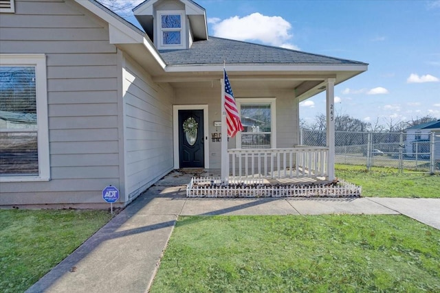 doorway to property featuring a lawn and covered porch