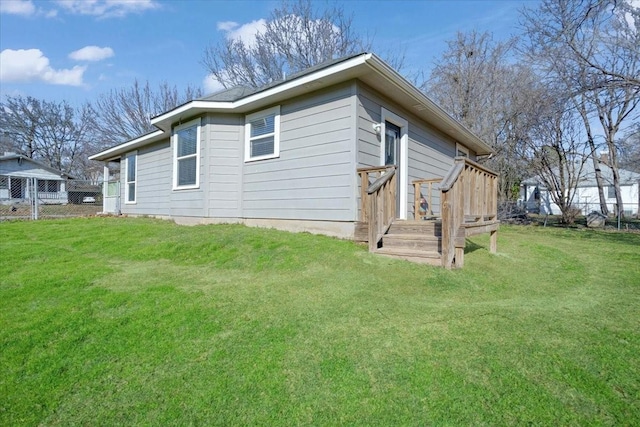 back of house with a lawn and a deck