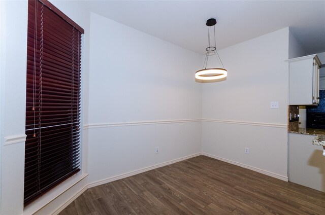 unfurnished dining area with dark wood-type flooring