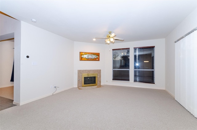 unfurnished living room featuring ceiling fan, a fireplace, and light colored carpet