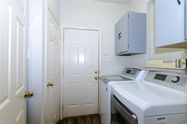 laundry area featuring cabinets, dark hardwood / wood-style flooring, and washing machine and clothes dryer