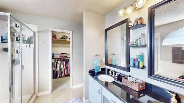 bathroom featuring a textured ceiling, tile patterned floors, vanity, and an enclosed shower