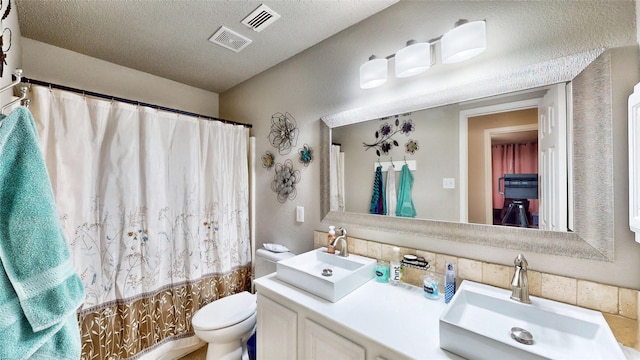 full bathroom with a textured ceiling, toilet, vanity, and shower / tub combo with curtain