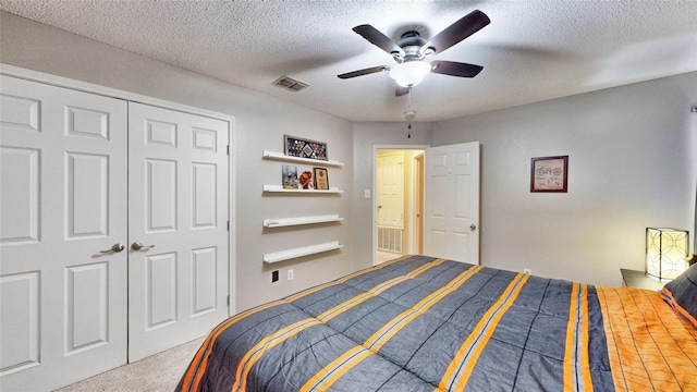 bedroom featuring ceiling fan, a textured ceiling, a closet, and carpet