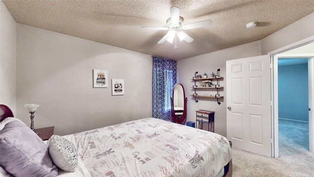 carpeted bedroom featuring ceiling fan and a textured ceiling