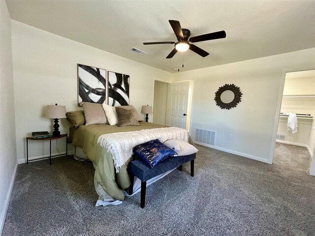 bedroom featuring dark colored carpet, ensuite bath, and ceiling fan