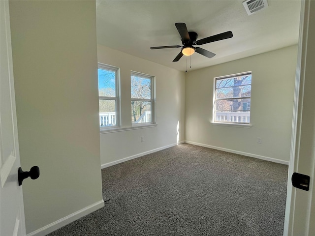 carpeted empty room featuring ceiling fan and a wealth of natural light