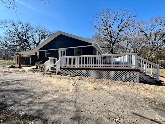 rear view of property featuring a wooden deck