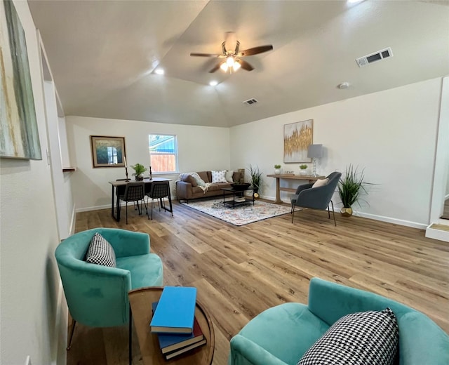 living room featuring ceiling fan, hardwood / wood-style floors, and vaulted ceiling