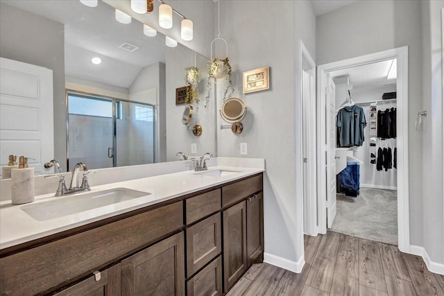 bathroom featuring hardwood / wood-style flooring, vanity, an enclosed shower, and vaulted ceiling