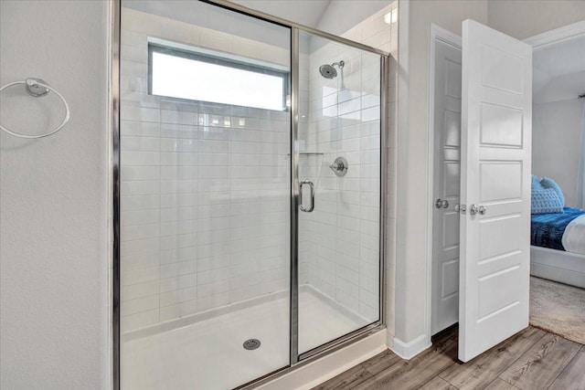 bathroom featuring an enclosed shower and wood-type flooring