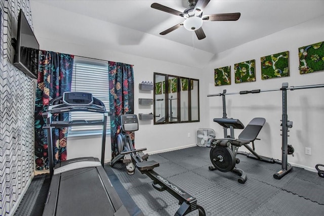 workout room with ceiling fan, a healthy amount of sunlight, and vaulted ceiling