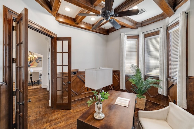 home office featuring ceiling fan with notable chandelier, coffered ceiling, ornamental molding, dark carpet, and beamed ceiling