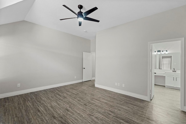 unfurnished bedroom featuring vaulted ceiling, ceiling fan, sink, hardwood / wood-style floors, and connected bathroom