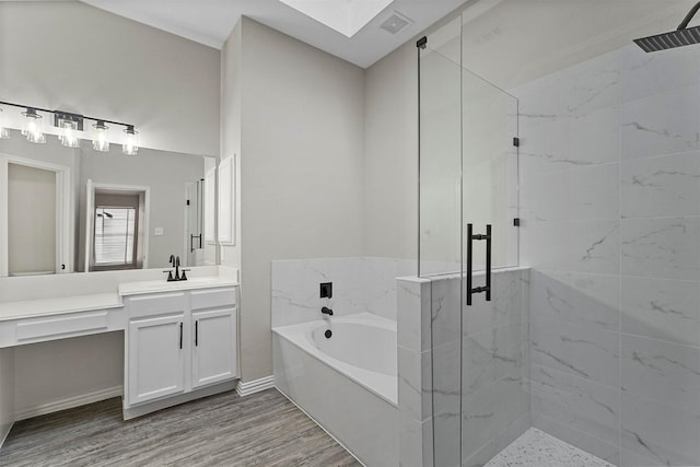 bathroom with plus walk in shower, wood-type flooring, and vanity