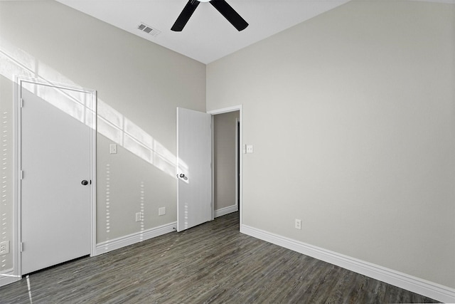 empty room featuring a high ceiling, dark hardwood / wood-style floors, and ceiling fan