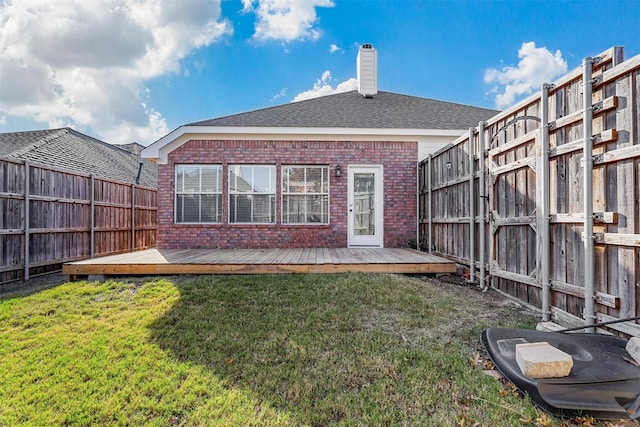 rear view of property featuring a yard and a deck