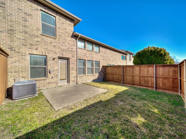 back of property with cooling unit, a lawn, and a patio