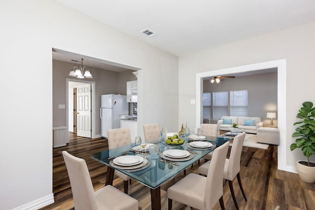 dining area featuring an inviting chandelier, radiator heating unit, and dark hardwood / wood-style flooring